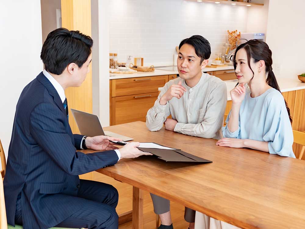 UNSTANDARD小野田のスタッフと家づくりの無料相談をする若い夫婦